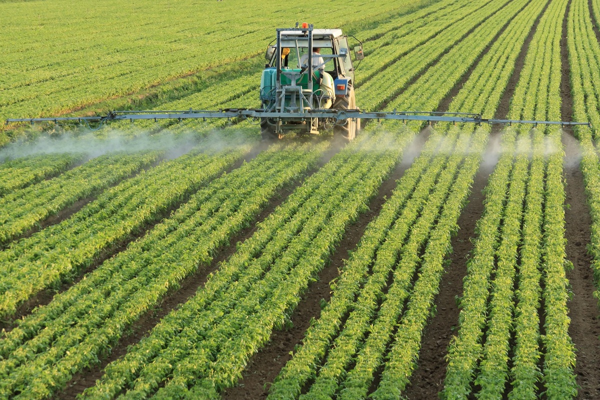 modern tractor operating in a field, utilizing precision agriculture techniques to spray crops